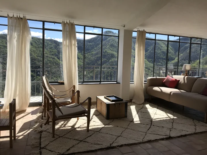 Living room of Casa Bahar with large windows and a view of the valley